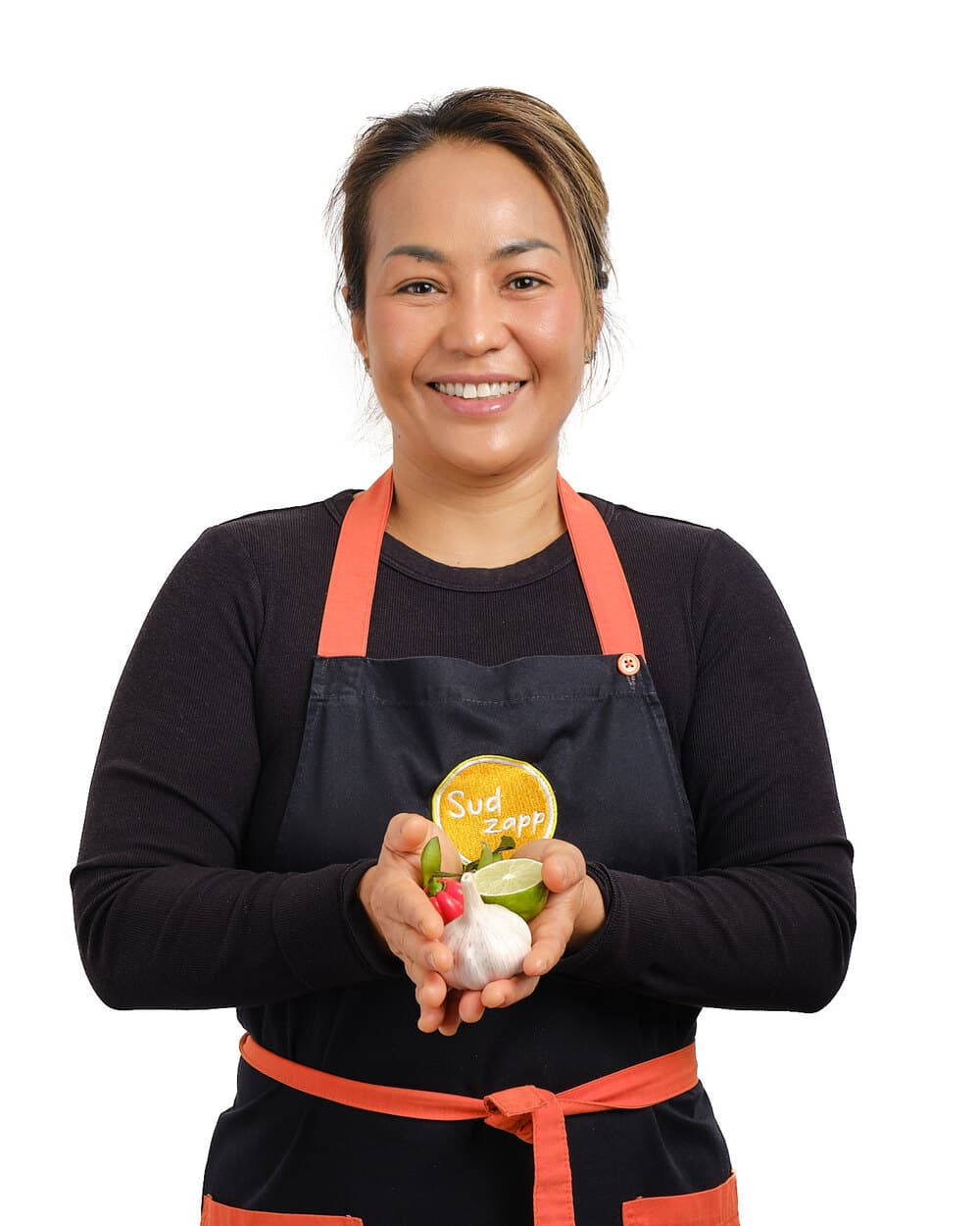 Bee, SudZapp’s founder and chef, holding fresh chilli, garlic and lime